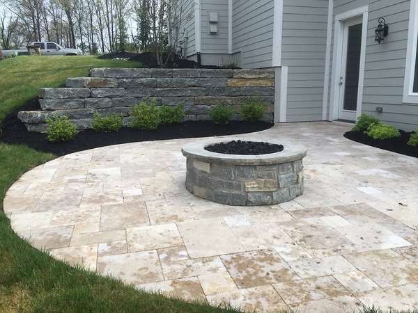 Stone retaining wall by patio with stone fire pit