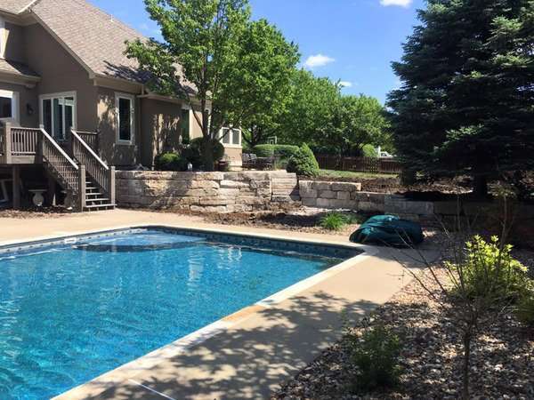 Stone retaining wall by pool