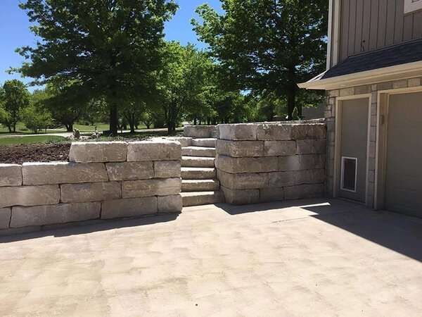 Stone retaining wall with stairs creating more space for a driveway